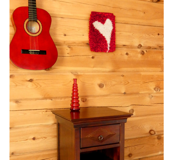 Handwoven wall hanging rug on log wall, white heart figure on red background,  20 x 30 cm, 7,87 x 11,8".
